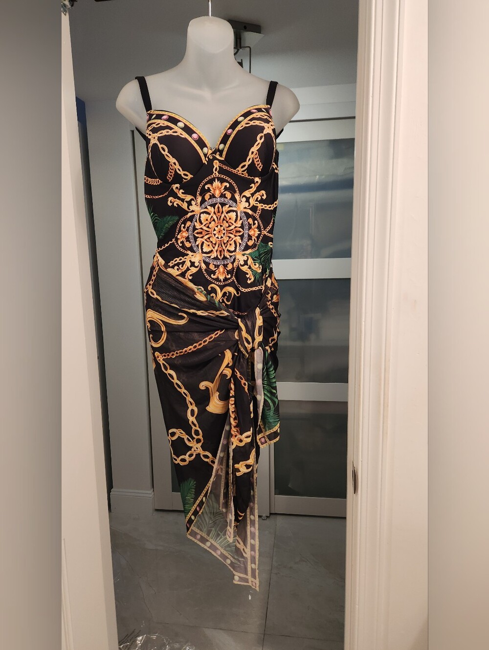 Black one-piece push-up swimsuit with a gold chain and leaf print